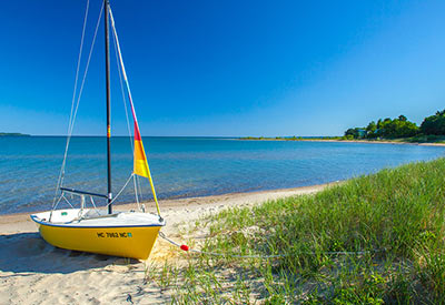small sailboat on sandy Lake Michigan beach