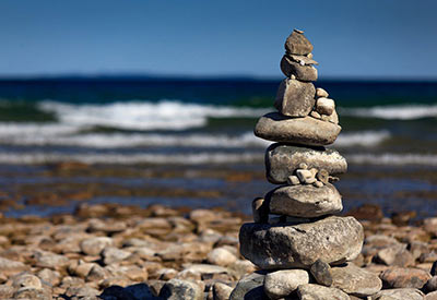 rocks stacked up on beach with waves in background